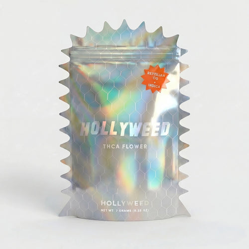 Hollyweed Reptilian OG THCA flower in a 7g mylar bag, showcasing dense indica buds with vibrant green and orange pistils.