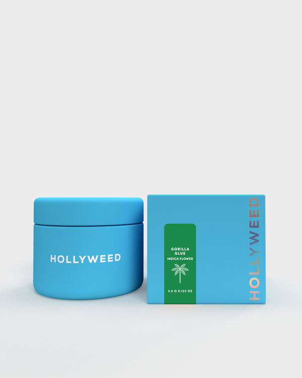 Hollyweed THCA flower Gorilla Glue strain in a jar and box, showcasing dense, green indica buds with orange hairs and trichomes.
